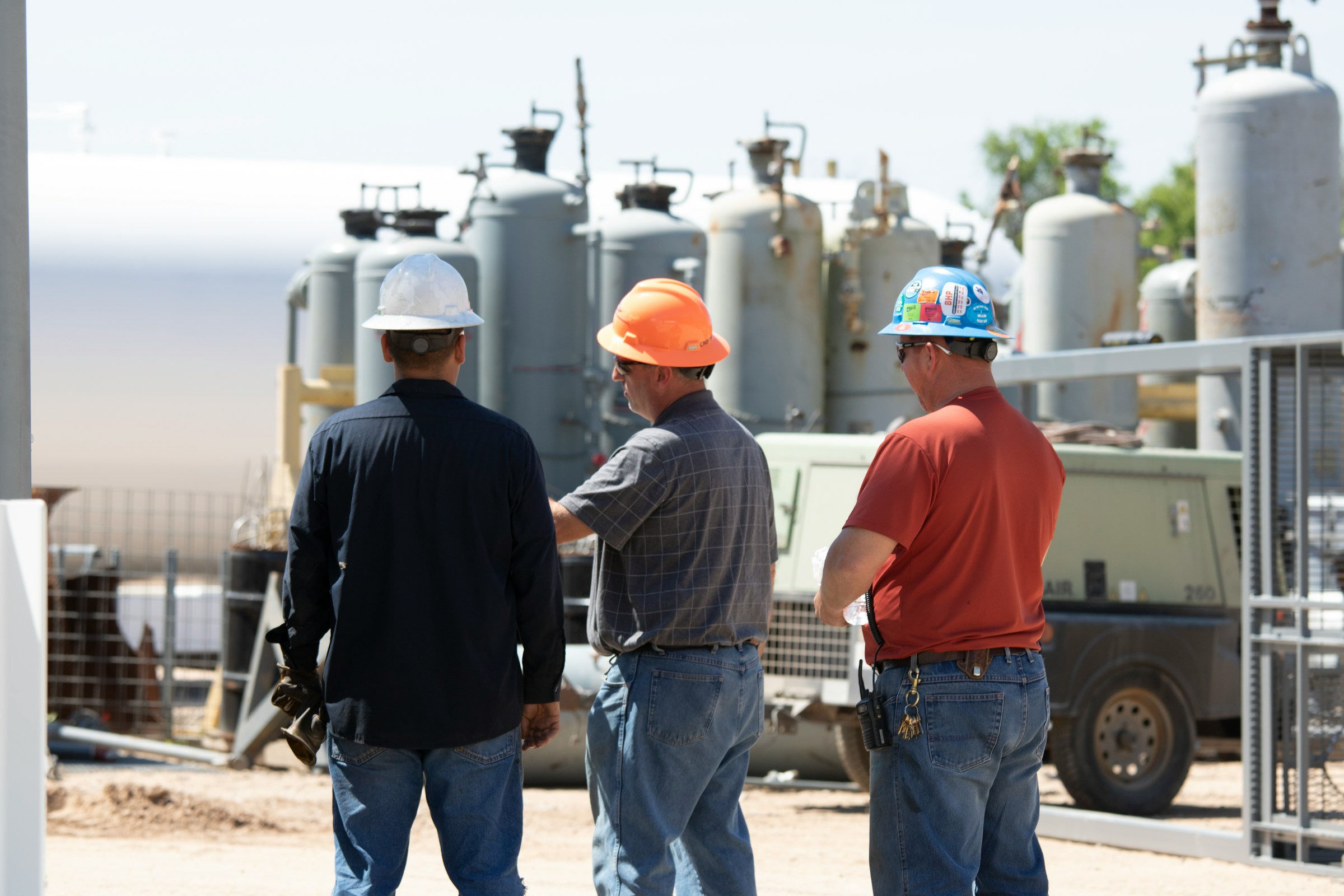 three construction workers standing next to one another