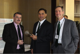 Commissioner Paul Roberti (RI PUC), passes the “torch” of Forum leadership to Commissioner Robert Scott (NH PUC) while Commissioner David Littell (ME PUC) looks on.